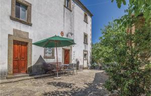 a table with a green umbrella in front of a building at Palazzo 1p in Polvano