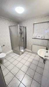 a bathroom with a shower and a toilet and a sink at Hotel am Kirschberg in Alten Buseck