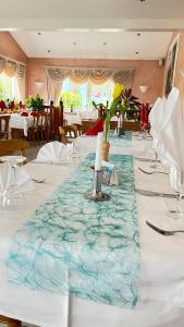 a long table with white table cloths and a candle on it at Hotel am Kirschberg in Alten Buseck