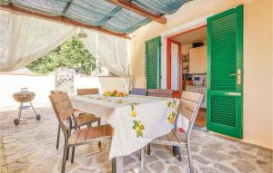 uma sala de jantar com uma mesa com cadeiras e persianas verdes em La Casa Dei Ricci em Camaiore