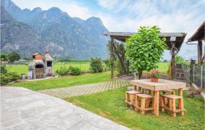 a picnic table in a garden with mountains in the background at Casa Meno in Novate Mezzola