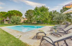 a swimming pool with chairs and a table next to it at Amazing Apartment In Ponte Alla Chiassa Ar With 3 Bedrooms, Wifi And Outdoor Swimming Pool in Chiassa Superiore