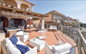 un balcón con sillas blancas y mesas en una casa en Gorgeous Home In Tarquinia vt With Wifi, en Tarquinia
