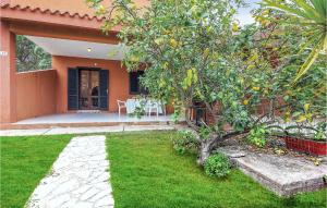 an orange house with a table and a tree at Lovely Apartment In Costa Rei -Ca- With Wifi in Monte Nai