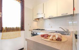 a kitchen with a plate of food on a counter at Lovely Apartment In Costa Rei -Ca- With Wifi in Monte Nai +6 photos