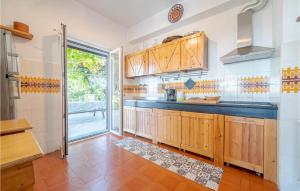 a kitchen with wooden cabinets and a large window at Pet Friendly Home In Moneglia With Kitchen in Moneglia