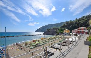 a beach with people on the sand and the water at Pet Friendly Home In Moneglia With Kitchen in Moneglia