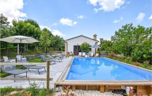 einen Pool mit Stühlen und einem Sonnenschirm in der Unterkunft Villa Genny in Cingoli