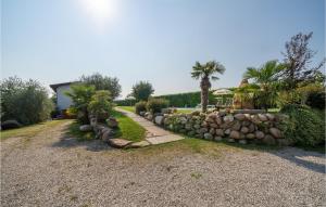 a garden with a stone wall and palm trees at Macchia Rossa in Caprino Veronese +17 photos