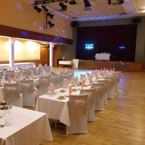 una fila de mesas en un salón de banquetes con sábanas blancas en Penzion a Restaurace Simanda, en Praga