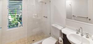 a white bathroom with a toilet and a sink at REEF RETREAT APARTMENTS PALM COVE Unit 13 in Palm Cove +20 photos