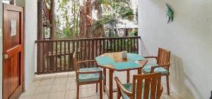 a wooden table and chairs on a balcony at REEF RETREAT APARTMENTS PALM COVE Unit 13 in Palm Cove