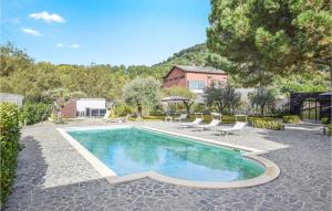 a swimming pool in a yard with chairs and a building at Nice Home In Nicolosi With Wifi in Nicolosi