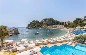 a beach with umbrellas and people swimming in the water at Nice Home In Nicolosi With Wifi in Nicolosi