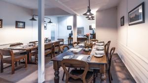 una sala da pranzo con tavoli e sedie in legno di Margaret River Guest House a Margaret River Town