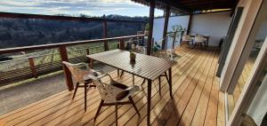 a wooden deck with a table and chairs on a balcony at Weingut & Ferienwohnungen Lenhard in Lang