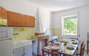 una cucina con tavolo e sedie e una cucina con finestra di 2 Bedroom Lovely Apartment In Sellia Marina a Sellia Marina