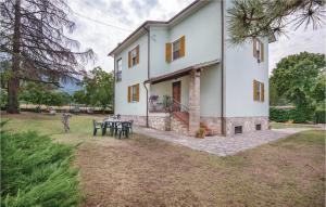 a large white house with a table in the yard at Awesome Home In Spoleto -pg- With 3 Bedrooms And Wifi in Bazzano Inferiore