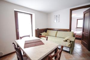 un soggiorno con divano e tavolo di Residence Aquila - Bilo Punta Goà a Brusson