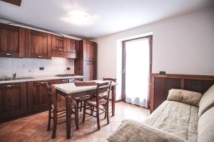 una cucina con tavolo, sedie e un letto di Residence Aquila - Bilo Punta Goà a Brusson