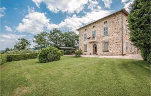 een groot stenen gebouw met een grasveld bij Tulipano in Pieve a Scuola