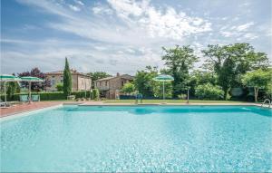 a large blue swimming pool with two umbrellas at Tulipano in Pieve a Scuola