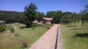 a brick path in a park with a house at Agriturismo Monte dell'Olmo in Trevignano Romano