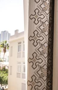 a curtain on a window in front of a building at The Norman Tel Aviv in Tel Aviv