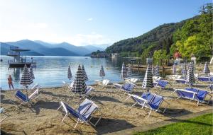 - un groupe de chaises longues sur une plage au bord de l'eau dans l'établissement Coccola Del Lago, à Gozzano