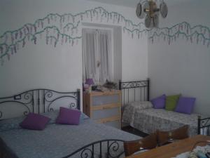 een slaapkamer met 2 bedden met paarse en groene kussens bij B&B Balestruccio in Pombia