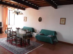 a living room with a table and a green couch at Palazzo Nanni in Montefalco +27 photos