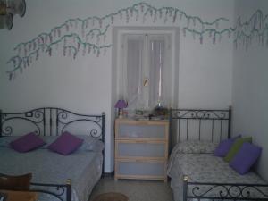 um quarto com 2 camas e uma cómoda com almofadas roxas em B&B Balestruccio em Pombia mais 10 fotografias