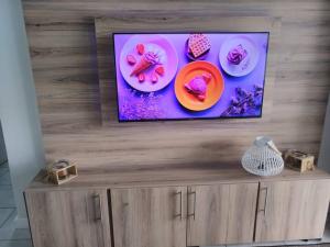 uma televisão de ecrã plano em cima de um centro de entretenimento em madeira em Breathtaking Lagoon View Apartment @ The Blyde1531 em Pretoria
