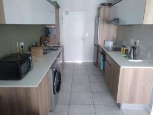 a small kitchen with a sink and a microwave at Breathtaking Lagoon View Apartment @ The Blyde1531 in Pretoria