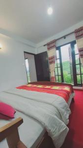 a large bed in a room with windows at Green Gregory Villa Nuwara Eliya in Nuwara Eliya