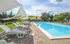 - une piscine avec des chaises longues et un grand parasol dans l'établissement Stalla, à Torrita di Siena