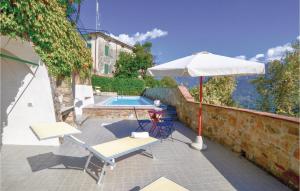 a patio with an umbrella and chairs and a pool at Riccio in Piano di Mommio