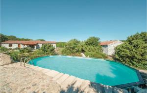 ein blauer Swimmingpool mit einem Haus im Hintergrund in der Unterkunft Mare Dei Ginepri Bilocale in Badesi