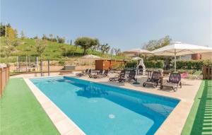 a swimming pool with chairs and umbrellas next to it at Casa Federica in Monte San Giusto