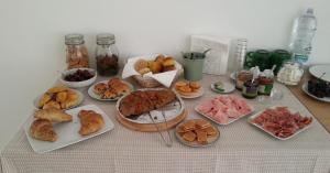 a table topped with different types of bread and pastries at La Casa Del Gelso Bianco in Otranto