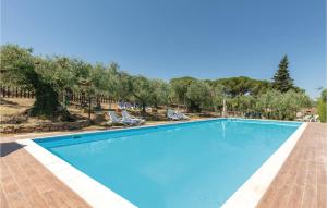 una piscina blu con sedie e alberi di Il Poeta a Montemelino