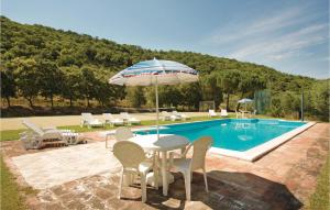 una mesa con sombrilla junto a la piscina en Il Molino - Casale Il Picchio, en Magione