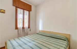 ロゾリーナ・マーレにあるVolpe 11のベッドルーム1室(ストライプ掛け布団、窓付)