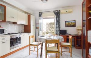 a kitchen with a table and chairs in a kitchen at Amazing Apartment In Piedimonte Etneo With 2 Bedrooms And Wifi in Piedimonte Etneo