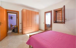 Schlafzimmer mit einem rosa Bett und Holzschränken in der Unterkunft 4 Bedroom Awesome Apartment In Trappeto in Trappeto