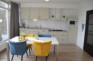 cocina con mesa blanca y sillas en Seapaerdje, en Bergen aan Zee