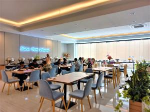 a group of people sitting at tables in a restaurant at Front One King Hotel Tuban in Tuban