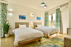 sypialnia z 2 łóżkami i dużym oknem w obiekcie Hurghada Sahl Hasheesh sea-view Villa with private pool w mieście Hurghada
