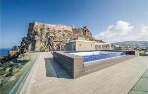 a house with a swimming pool in front of a mountain at Miramare in Castelsardo