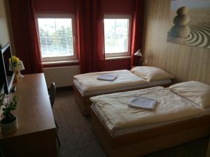 a hotel room with two beds and two windows at Hotel Pohádka in Most